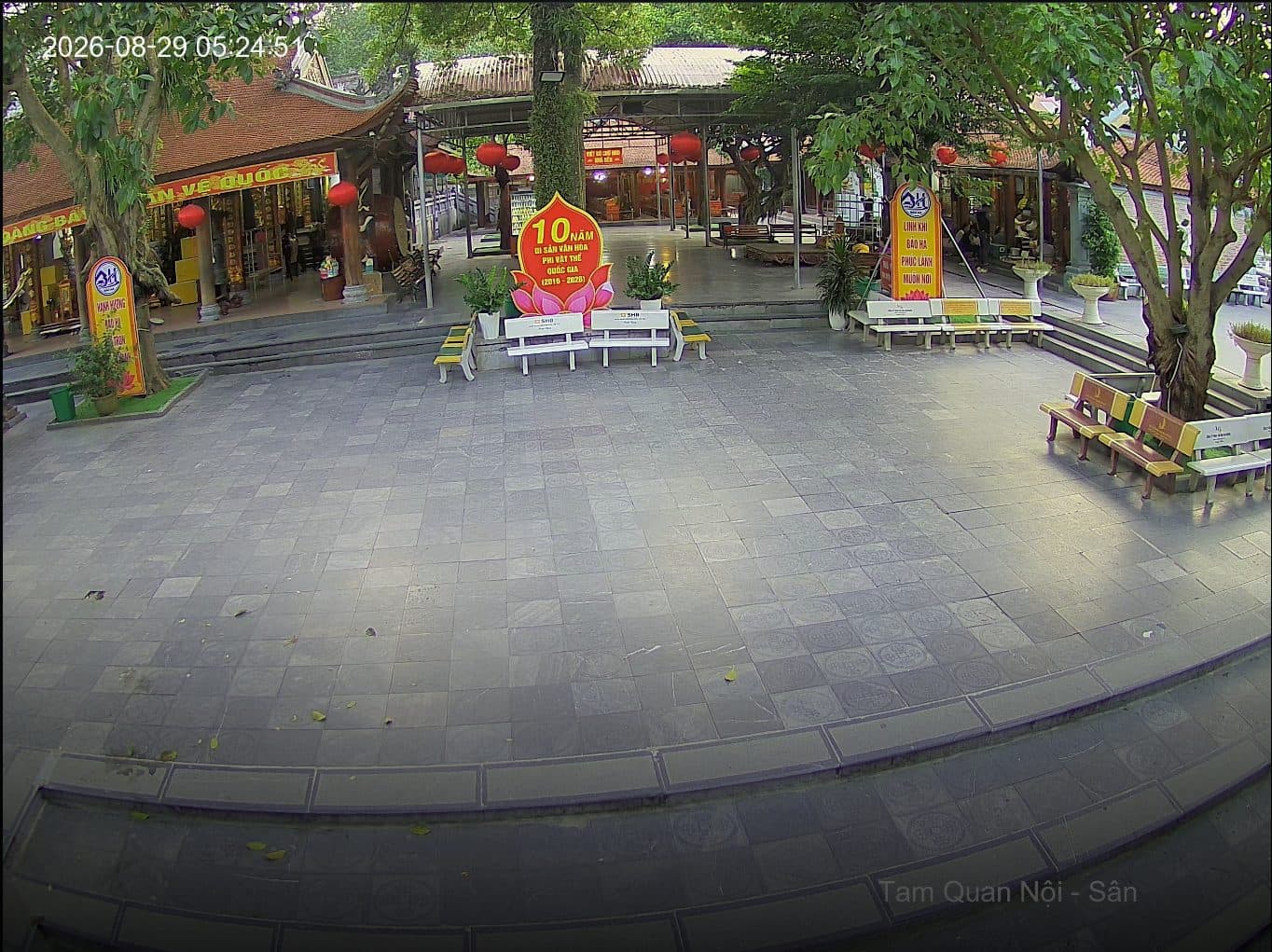 Inner gate courtyard of Bao Ha Temple from a security camera, with the worship hall and a 10-year national intangible heritage sign behind